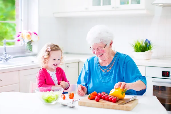 Büyükanne ve küçük kız salatası yapmak — Stok fotoğraf