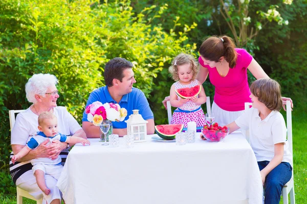 Familie eten fruit in de tuin — Stockfoto