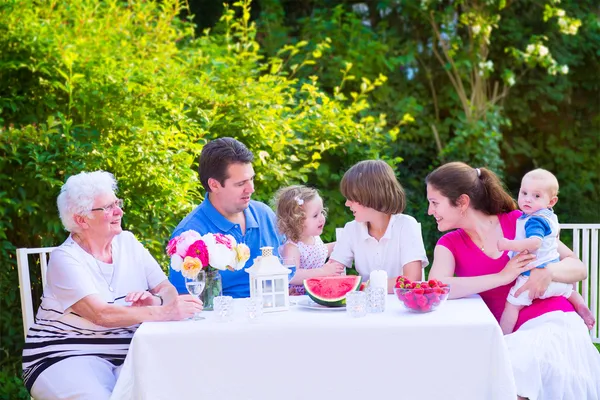 Famiglia mangiare frutta in giardino — Foto Stock