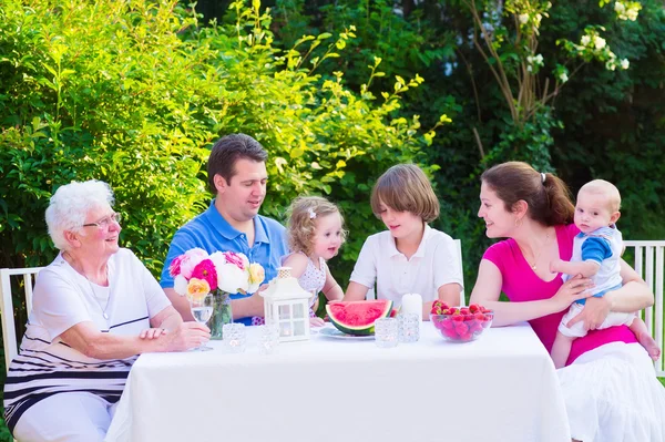 Famille manger des fruits dans le jardin — Photo