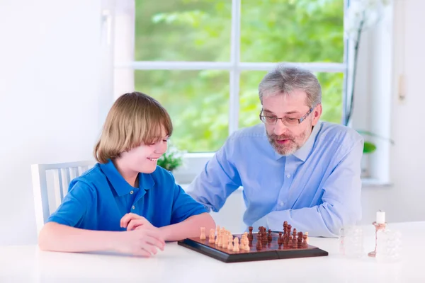 Happy grandfather playing chess with his grandson — Stock Photo, Image