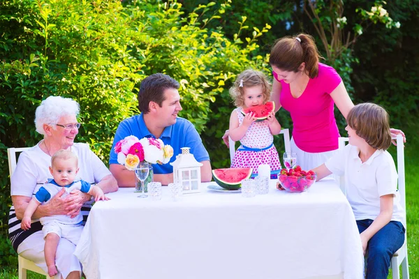 Famille manger des fruits dans le jardin — Photo