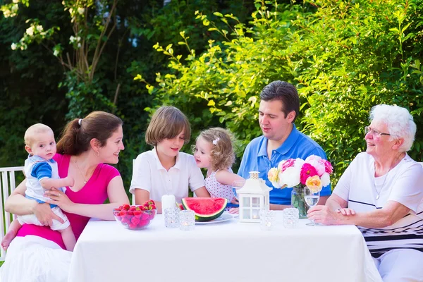 Familie eten fruit in de tuin — Stockfoto