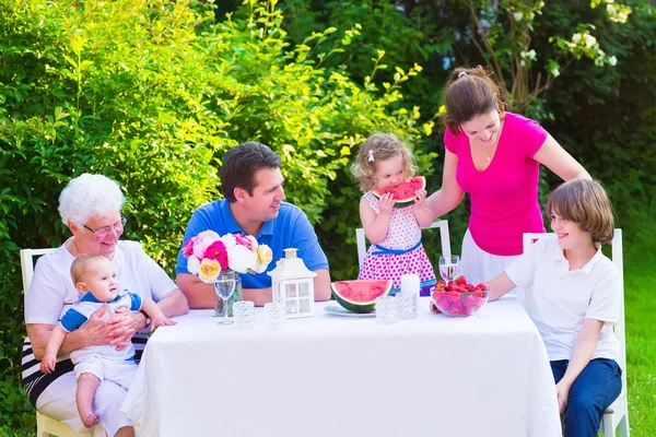 Famille manger des fruits dans le jardin — Photo