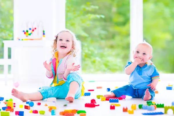 Broer en zus spelen met kleurrijke blokken — Stockfoto