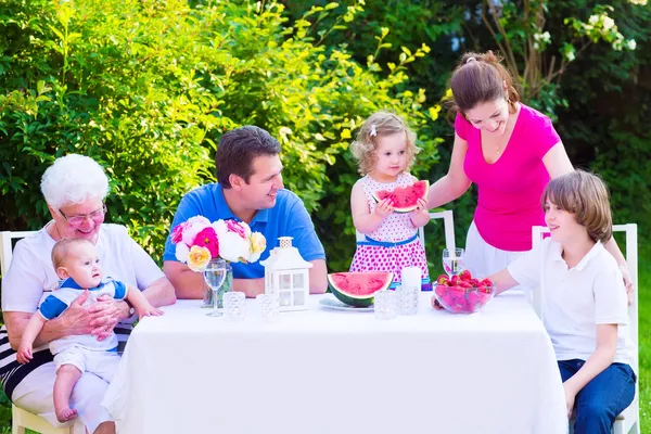 Семья ест фрукты в саду — стоковое фото