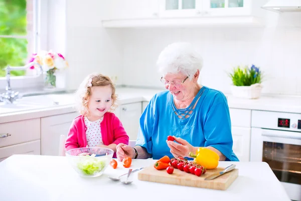 Büyükanne ve küçük kız salatası yapmak Telifsiz Stok Imajlar