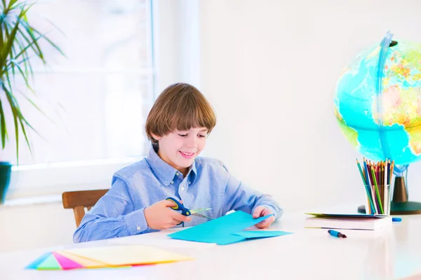 Улыбающийся мальчик, выполняющий домашнюю работу — стоковое фото