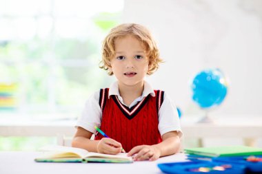 Okuldaki çocuklar. Anaokulu çocukları sınıfta. Mutlu çocuklar okula geri dönüyor. Sınıfta öğrenci. Çocuk okuma yazma öğreniyor. Eğlenceli öğrenme. Küçük çocuklar için eğitim. Küçük kız ve erkek çocuk çalışıyor..