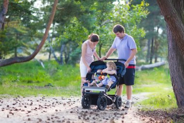 Genç aile içinde bir bebek arabası iki çocukla hiking