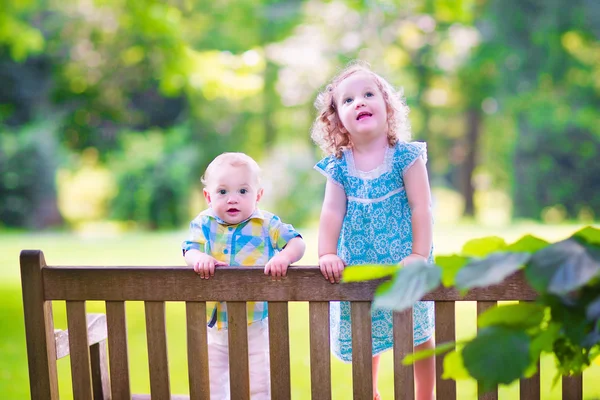 Brother and sister on a park bench — Stock Photo, Image