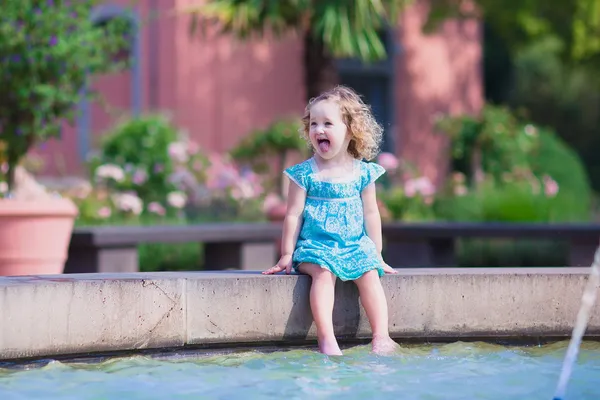 Маленькая девочка освежается в фонтане — стоковое фото