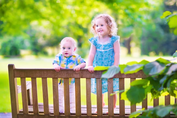 Двое детей на скамейке в парке — стоковое фото