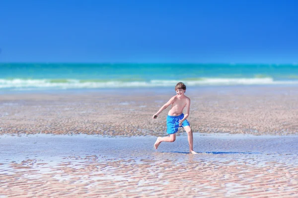 Ragazzo che corre su una spiaggia — Foto Stock