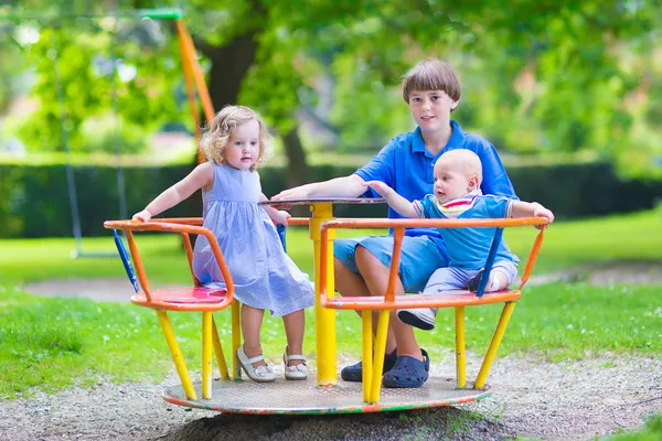 Troje dzieci na huśtawce — Zdjęcie stockowe