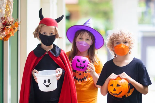 아이들은 할로윈 복장을 마스크를 쓰거나 속임수를 씁니다 코로나 바이러스 유행병에서 — 스톡 사진