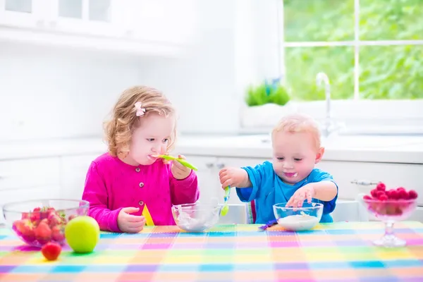 Двое детей едят йогурт — стоковое фото