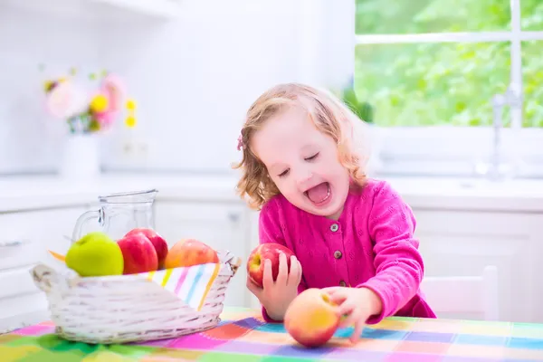 Маленькая девочка ест яблоки — стоковое фото