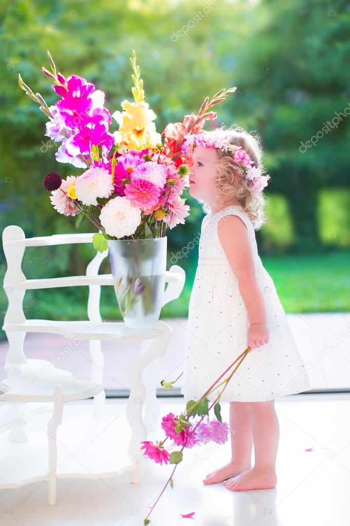 Little girl smelling flowers at home
