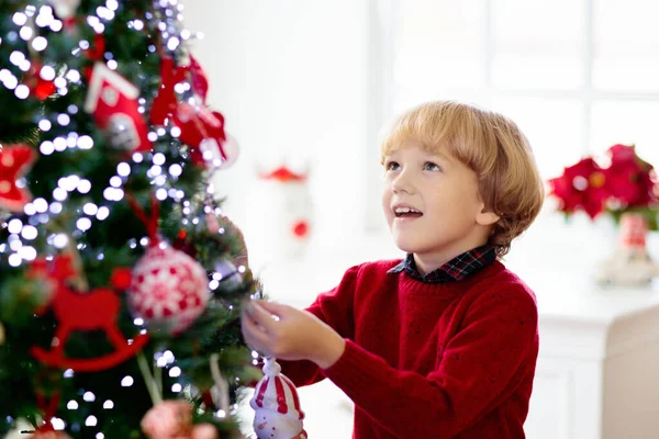 孩子们在家里装饰圣诞节 圣诞节早上的礼物和礼物 穿着针织毛衣 头戴装饰品的小男孩 家里人庆祝寒假 孩子们装饰客厅和窗户 — 图库照片