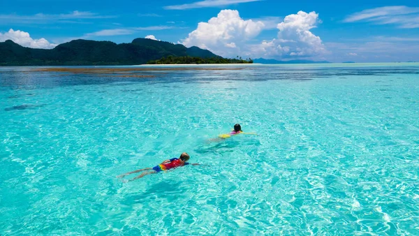 孩子们在打喷嚏海滩乐趣 孩子们在热带海域潜水 在异国情调的岛上度过家庭暑假 带着面具和鳍的孩子和家人一起旅行小孩在学潜水 潜水假期 — 图库照片