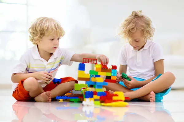 カラフルなおもちゃのブロックで遊ぶ子供 子供たちはプラスチックレンガで遊ぶ 少年の建物の塔と宇宙船 子供のための教育玩具 就学前または幼稚園の教室 家で子供 — ストック写真