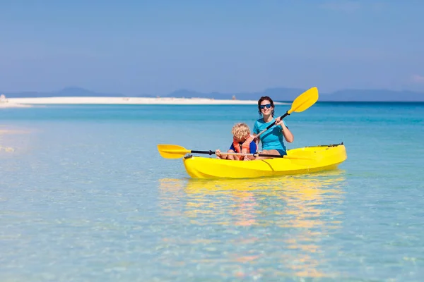 子供たちは海でカヤック 熱帯の海でカヤックの子供たち 若い子供とのアクティブな休暇 美しいビーチでカヌーの両親 男の子と女の子 子供との休日の活動 家族の水の楽しみ — ストック写真