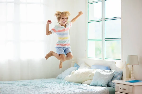 Niño Saltando Cama Dormitorio Blanco Con Ventana Grande Los Niños —  Fotos de Stock