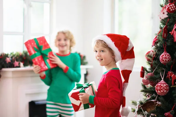 Παιδιά Στο Χριστουγεννιάτικο Δέντρο Και Τζάκι Την Παραμονή Των Χριστουγέννων — Φωτογραφία Αρχείου
