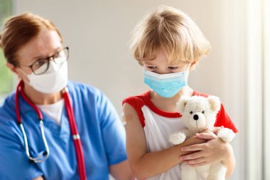 Covid-19 aşısından sonra ağlayan bir çocuk. Genç çocuklar için koronavirüs aşısı. Doktor hastaya covid iğnesi yapıyor. Ergenler ve çocuklar için bağışıklık programı. Sağlık hizmetleri. Çocuk doktorundaki çocuk..