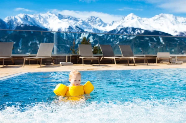 在室外游泳池的豪华的阿尔卑斯山 奥地利阿尔卑斯山度假胜地玩的小孩 冬季冰雪度假与孩子 在户外与山景的热水浴缸 儿童戏剧和游泳 — 图库照片