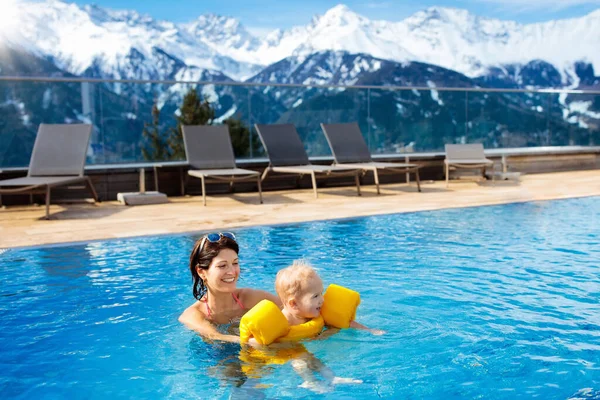 妈妈和宝宝一起玩在室外游泳池的豪华水疗阿尔卑斯山 奥地利阿尔卑斯山度假胜地 冬季冰雪度假为有孩子的家庭的 孩子们在户外与山景的热水浴缸 — 图库照片
