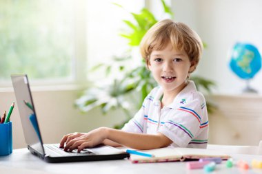 Çevrimiçi uzaktan öğrenme. Bilgisayarlı okul çocukları öğretmen ve sınıf grubuyla görüntülü konuşma yapıyorlar. Çocuk evden ders çalışıyor. Karantina ve koronavirüs salgını sırasında evde eğitim.