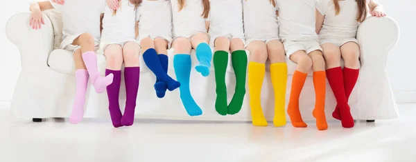カラフルな虹の靴下を着ている子供たち 子供靴コレクション ニット膝の高い靴下やタイツの様々な 子供服やアパレル 子供のファッション 足と足の小さな男の子と女の子のグループ — ストック写真