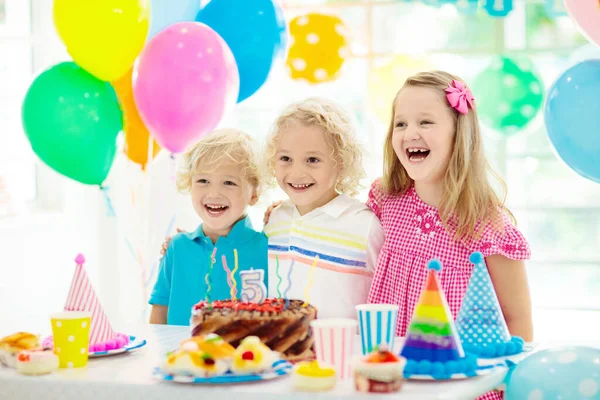 孩子们的生日聚会 孩子在五颜六色的蛋糕上吹蜡烛 装饰的家与彩虹旗横幅 农场动物主题庆典 庆祝生日的小男孩 宴会食品 — 图库照片