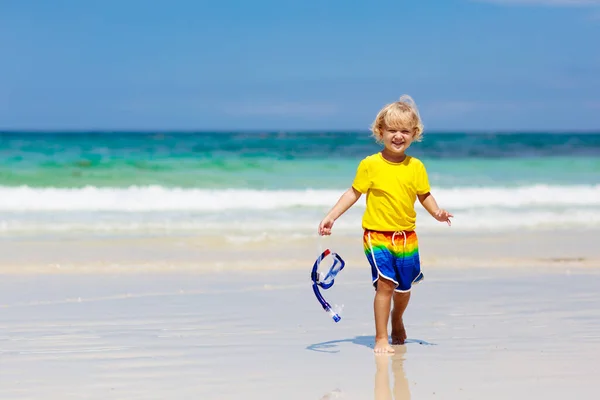 熱帯のビーチでシュノーケ リングの子 子供家族の夏休みにエキゾチックな島の海でシュノーケル 小さな男の子が海で海岸に砂と水を再生します 幼児は 波のように実行しています 子供のためのビーチ楽しい — ストック写真