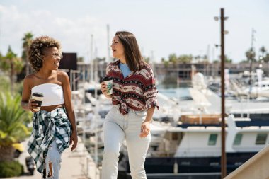 İki çok ırklı kadın eğleniyor, şehirde dolaşıyorlar.