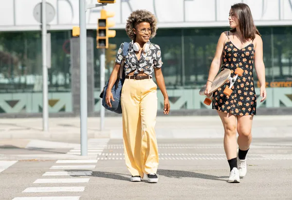 アフリカ系アメリカ人女性と白人女性がゼブラ交差点を歩く — ストック写真