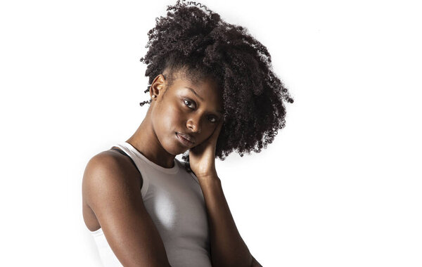 Studio portrait young afro american woman looking at camera positive and contemplative daydreaming isolated background