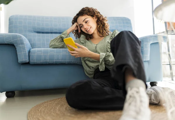 Mujer Pelo Rizado Sentado Sofá Con Teléfono Móvil —  Fotos de Stock