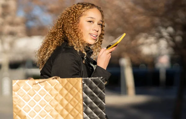 Pretty Hispanic Curly Haired Woman Shopping Bags Talking Mobile Phone — Foto Stock