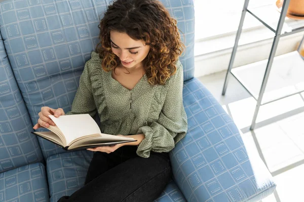 Visão Ângulo Baixo Mulher Cabelos Encaracolados Lendo Livro Sofá Mulher — Fotografia de Stock