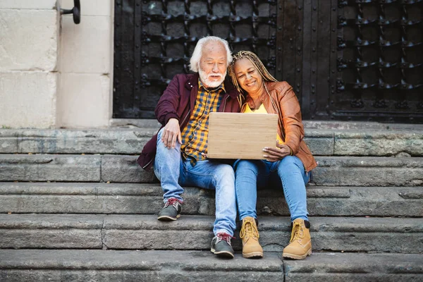 Beautiful Senior Multiethnic Elderly Couple Using Technology Computer Sitting Stairs — Stock Photo, Image