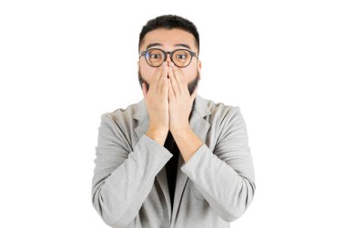 Beyaz arka planda Amerikan ceketli ve gözlüklü yakışıklı Asyalı sakallı adam şaşırmış ve korkmuş görünüyor..