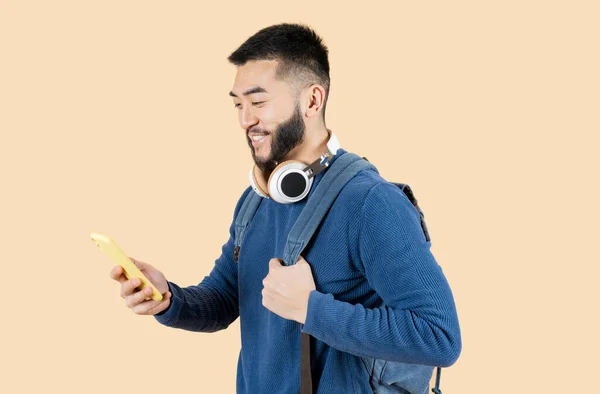 Joven Sonriente Hombre Asiático Con Auriculares Teléfono Celular Sosteniendo Una — Foto de Stock