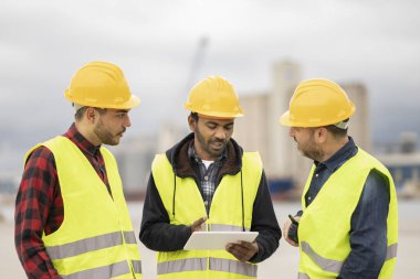 İnşa konteynır tersanesinde çalışan Hintli mühendis. İş ve denetleyici konteyner verilerini inceliyor. Konteynır nakliye lojistik mühendisliği kavramı.