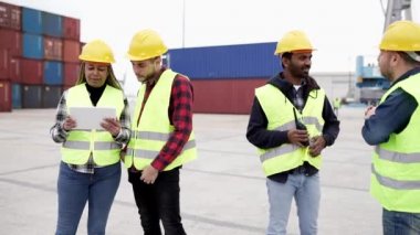 Çok ırklı liman nakliye lojistik işçileri, ithalat için kargo gemisinden konteynır yükleme izleme sistemi.