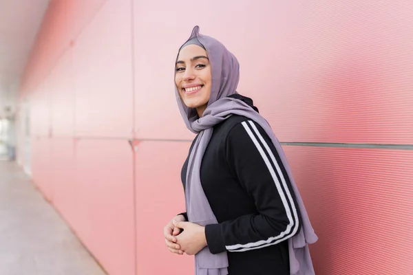 Sportowa Kobieta Hidżabie Gotowa Biegu Czerwonej Ścianie Spoglądająca Bok Uśmiechem — Zdjęcie stockowe