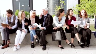 Yaratıcı iş ekibi toplantısı. Bir grup genç ve yaşlı iş adamı, güneşli bir günde, açık havada bir toplantıda, başlangıç fikirlerini tartışıyor..