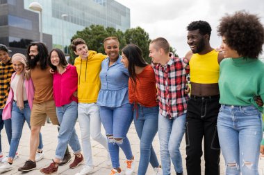 Bir grup çok ırklı arkadaş, çeşitlilik, şehirde mutlu bir şekilde dolaşmak.